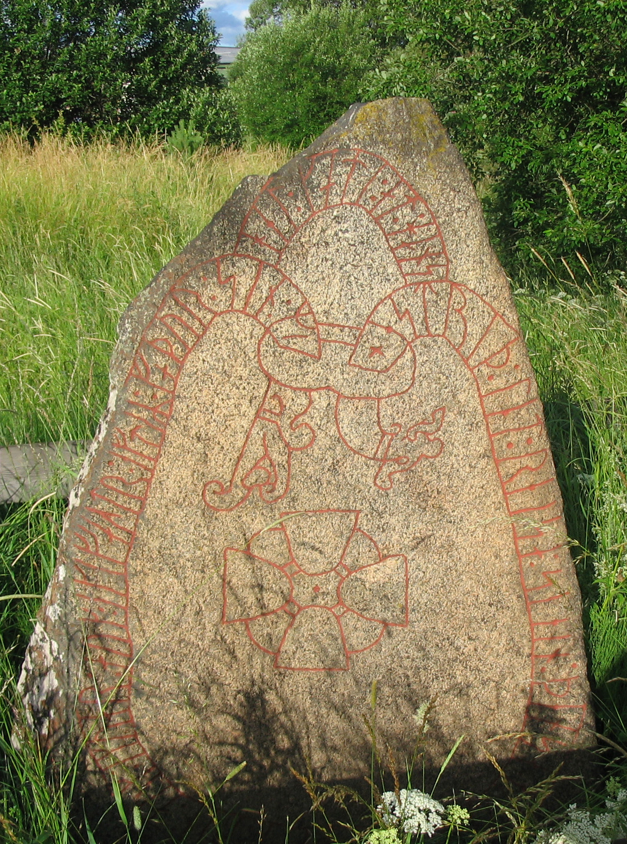 11th century runestone at Knivsta, south of Upssala, Sweden. The runestone reads: 'Ástríðr lét reisa stein þenna eptir Jóar/Ívar, bónda sinn, ok Ingvarr ok Ingifastr eptir fôður sinn. Mikjáll gæti ônd hans.' Translation: 'Ástríðr had this stone raised in memory of Jóarr/Ívarr, her husbandman; and Ingvarr and Ingifastr in memory of their father. May Michael protect his spirit.' Image source: www.commons.wikimedia.org